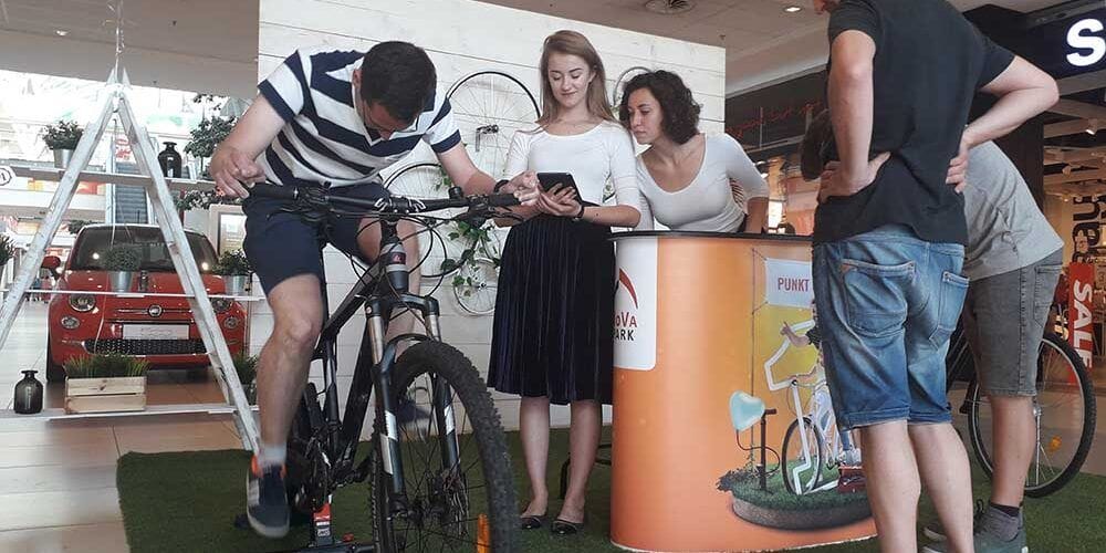 Uczestnik próbuje roweru przy stanowisku promocyjnym