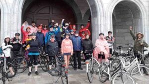Grupa uczestników wycieczki rowerowej przed zabytkowym budynkiem 2